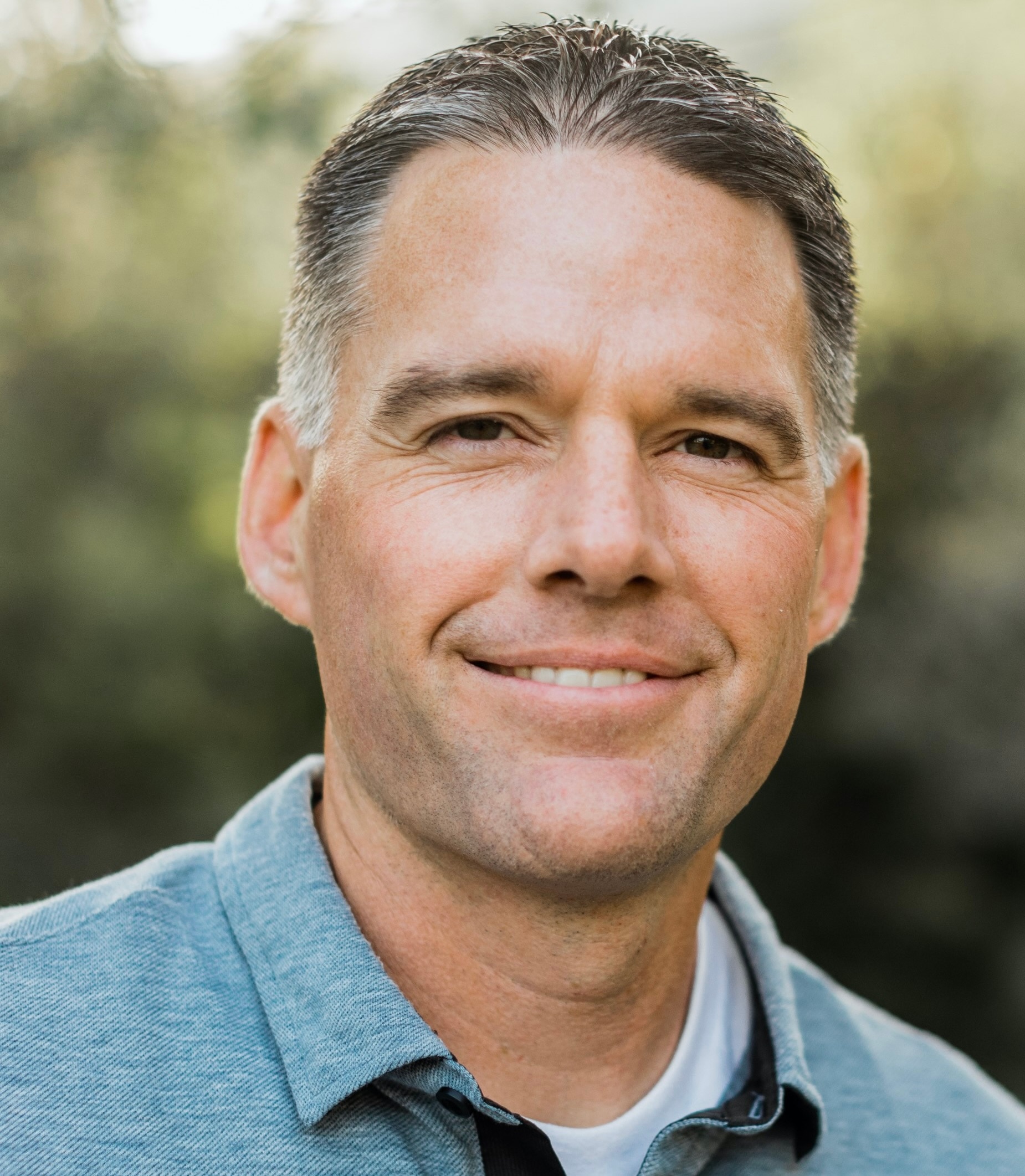 A person with a smile on his face sitting on a bench.